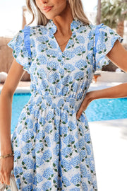 White cotton blend midi dress with blue hydrangea print, flutter sleeves, and smocked waist.