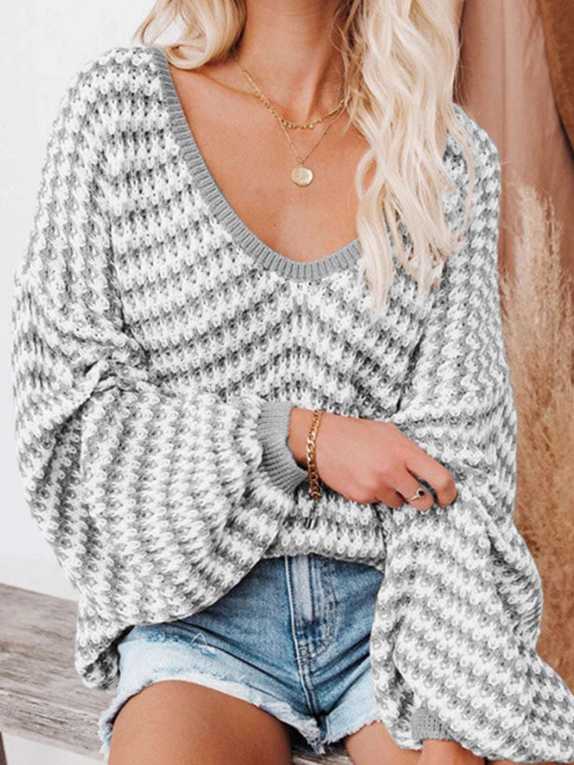 Geometric knit v-neck sweater with bell sleeves in grey and white acrylic.