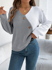 Asymmetrical colorblock knit sweater in gray and white with button detail.