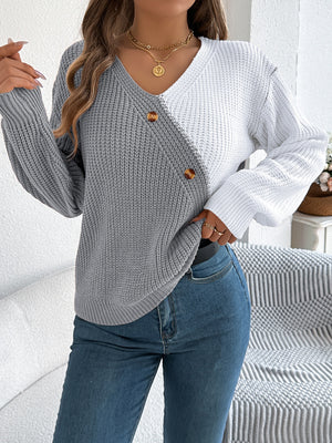 Asymmetrical colorblock knit sweater in gray and white with button detail.