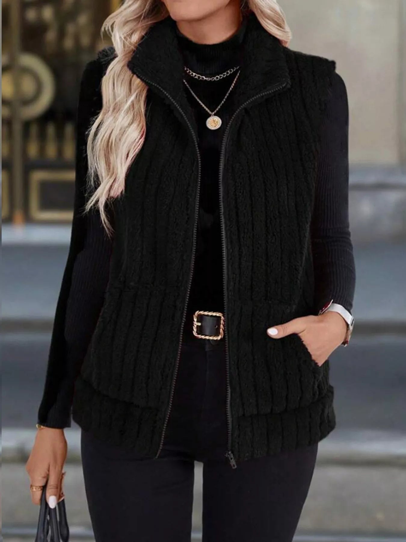 Black fleece zip-up vest with pockets and a stand-up collar.