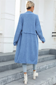 Light blue longline knit cardigan with fringe trim detail and relaxed fit.