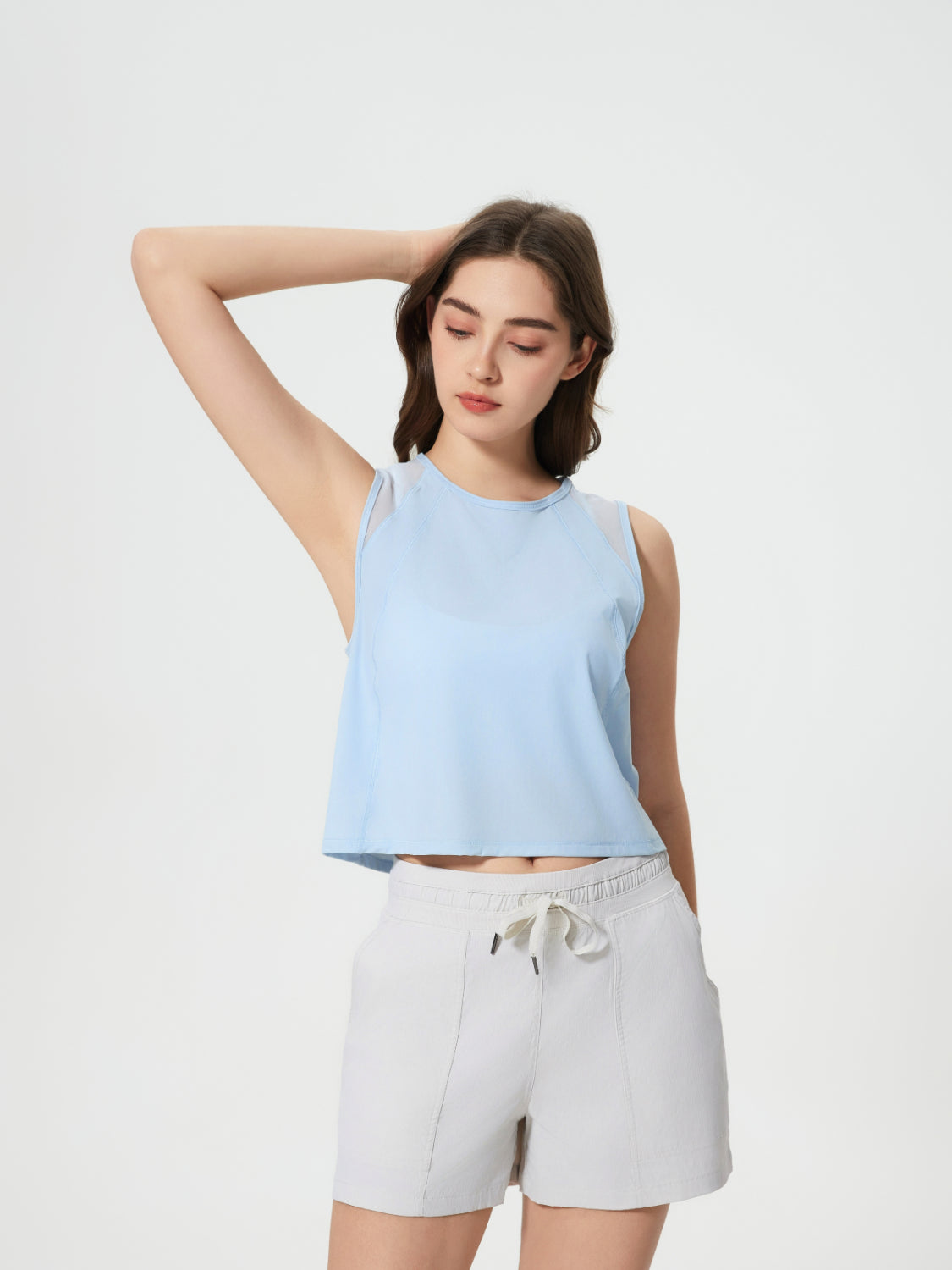 Baby blue cropped active tank top with mesh inset shoulders.