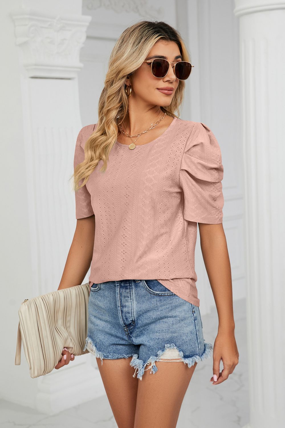 Pink perforated sleeve blouse with textured fabric and scoop neck.
