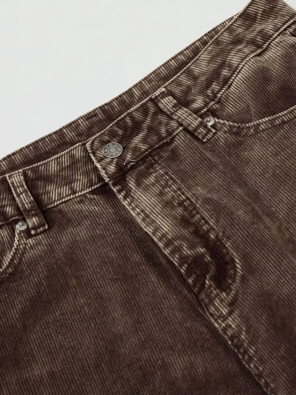 Brown corduroy joggers for men, featuring a button fly and classic pocket details.