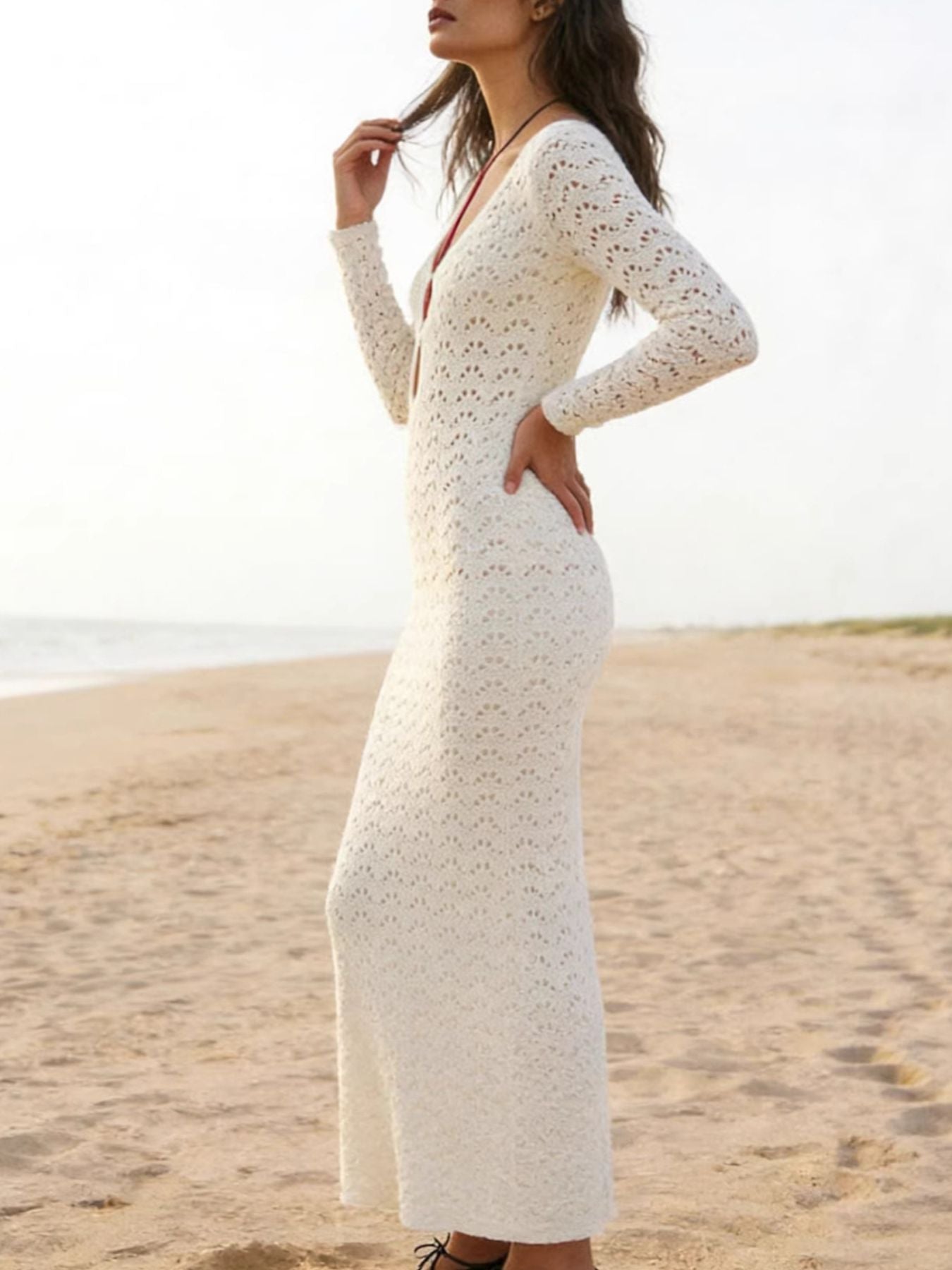 White crochet maxi cover-up dress with long sleeves and a deep V-neckline.