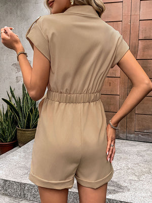 Camel utility romper with tie-waist detail, collared, short sleeves, and cuffed shorts.