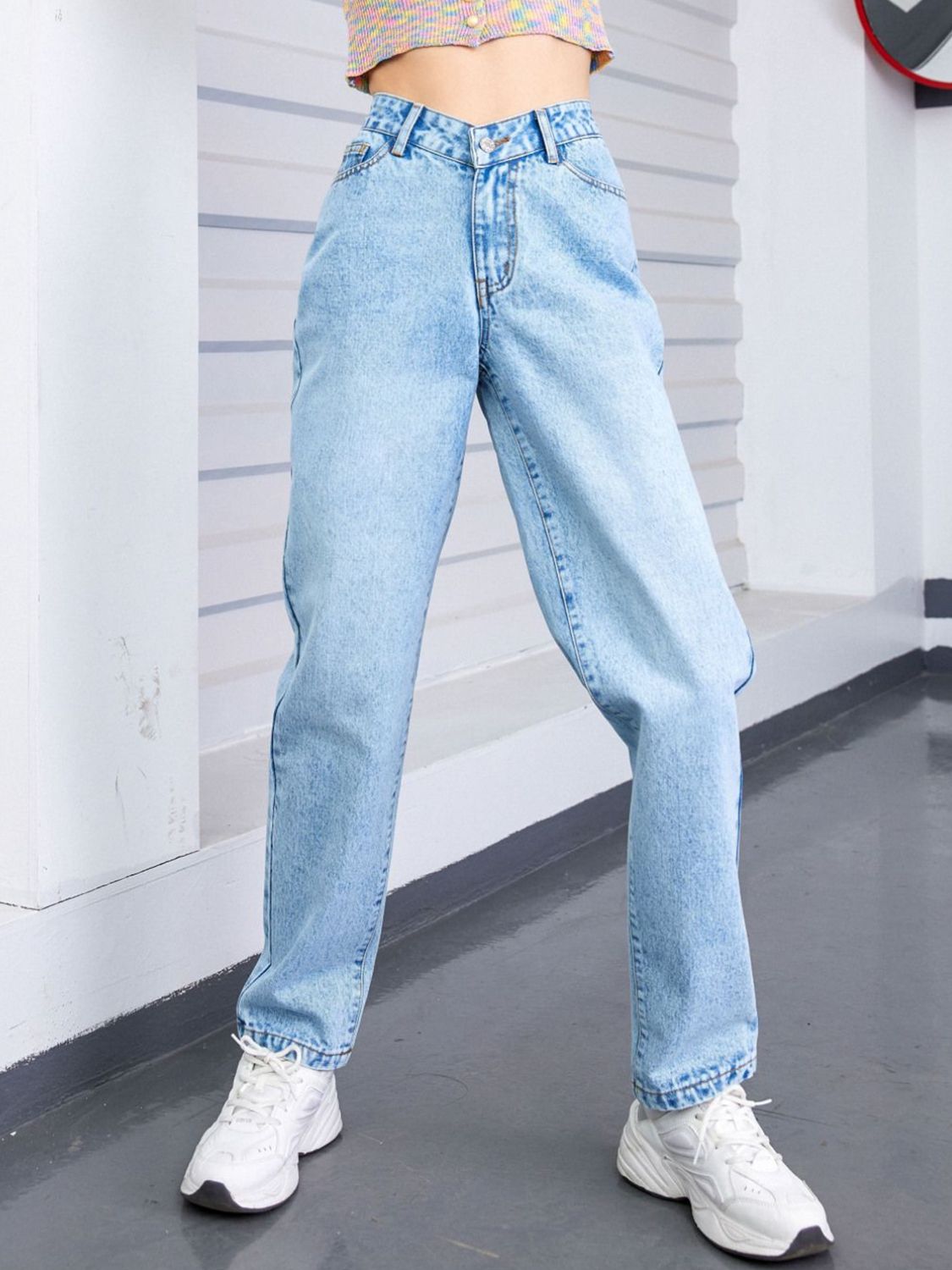 Light wash denim jeans with V-waistline and relaxed fit, buttoned closure.