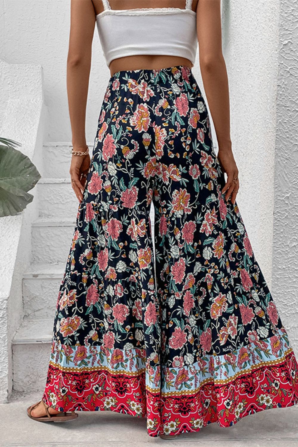 Floral border palazzo trousers with a wide leg and tiered hem, styled with a white crop top.
