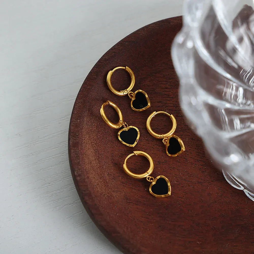 Gold hoop earrings with black enamel heart charms