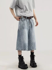 Men's light wash denim capris with a relaxed fit and wide leg, styled with a brown belt and black boots.