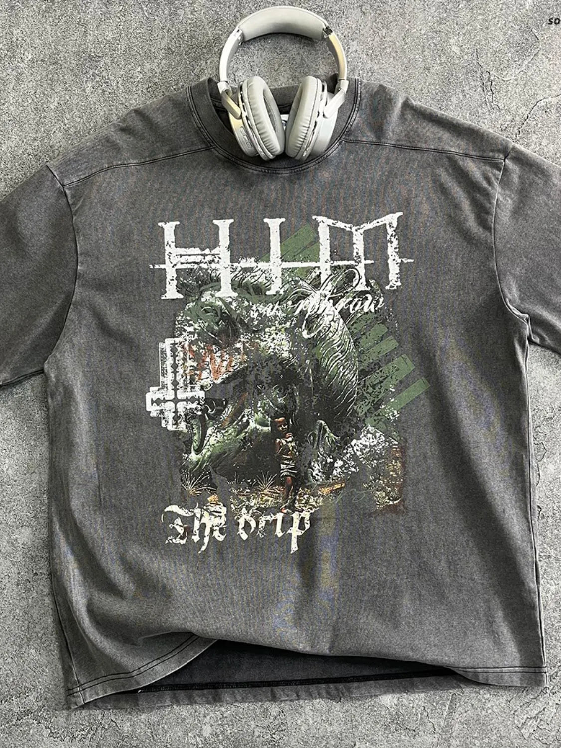 Acid wash graphic t-shirt in dark gray with a distressed monster graphic and text that reads "The Drip".