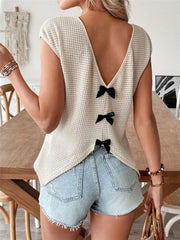 Apricot waffle knit v-neck shirt with cap sleeves and black bow details down the back.