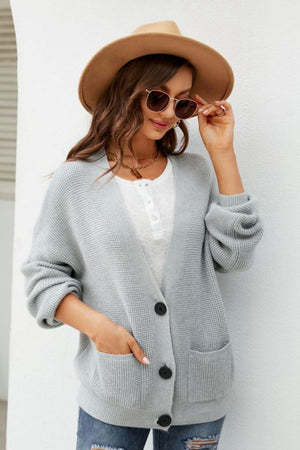 Light gray textured knit cardigan with oversized pockets and button front, styled with a white henley.