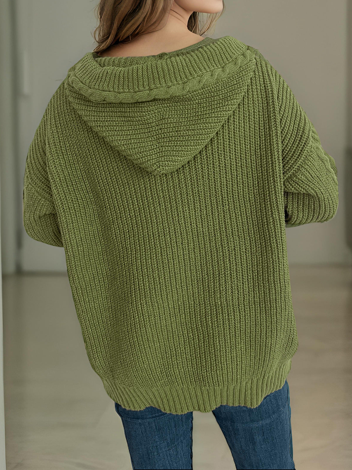 Moss green cable knit hoodie with toggle detail and ribbed texture.