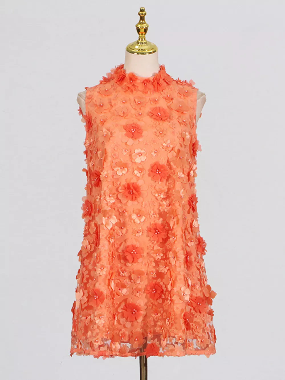 Orange ruffled floral applique mini dress with a high neckline and sleeveless cut.