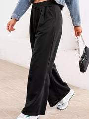 Black cotton drawstring high-waisted pleated maternity pants with a relaxed fit.