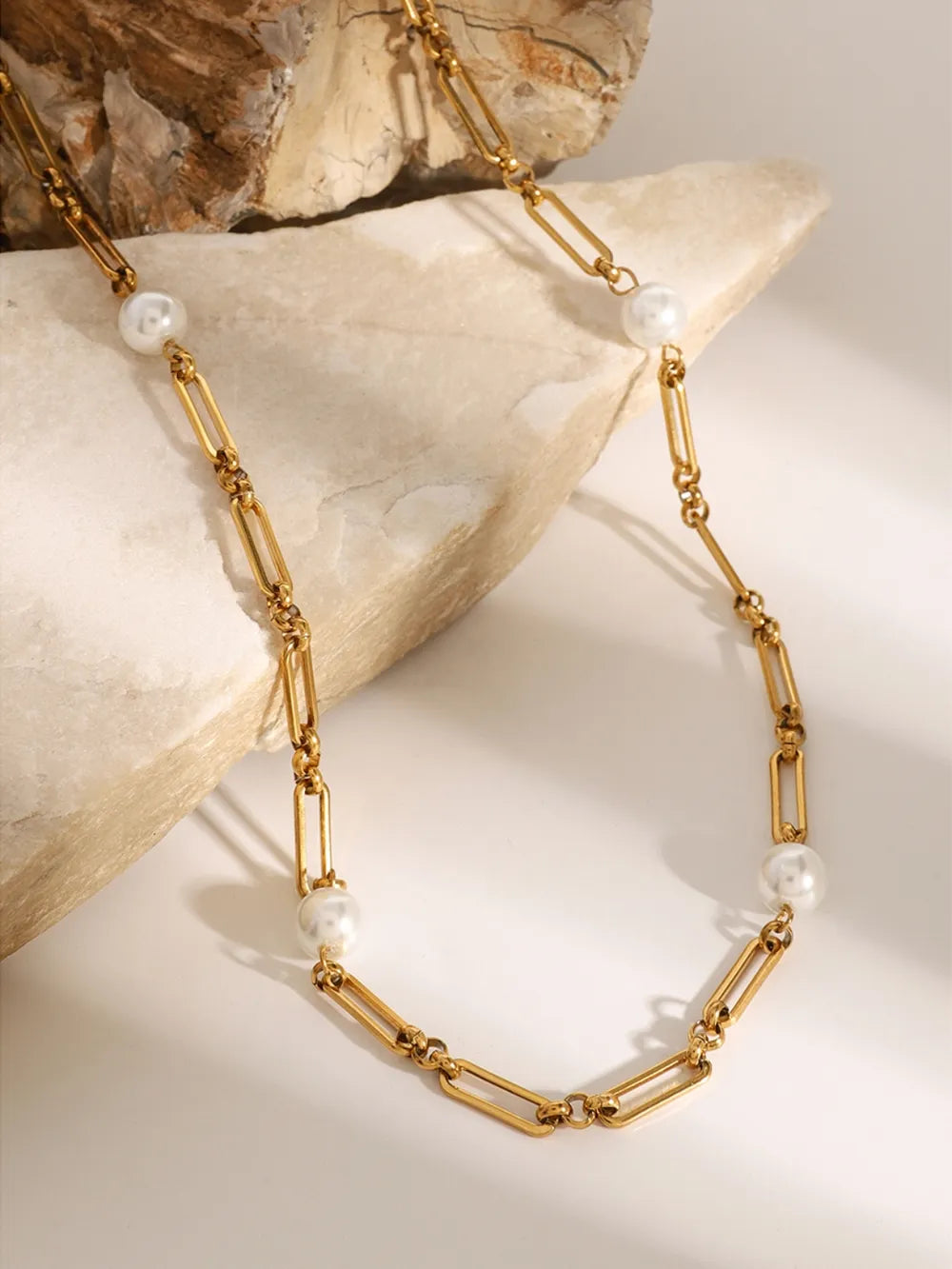 Gold two-tone pearl link necklace with elongated oval chain links and round pearls.