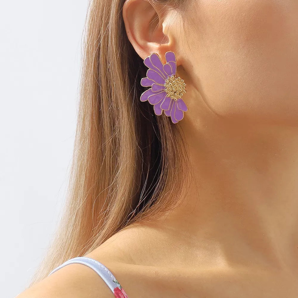 Purple flower stud earrings with gold textured center detail.