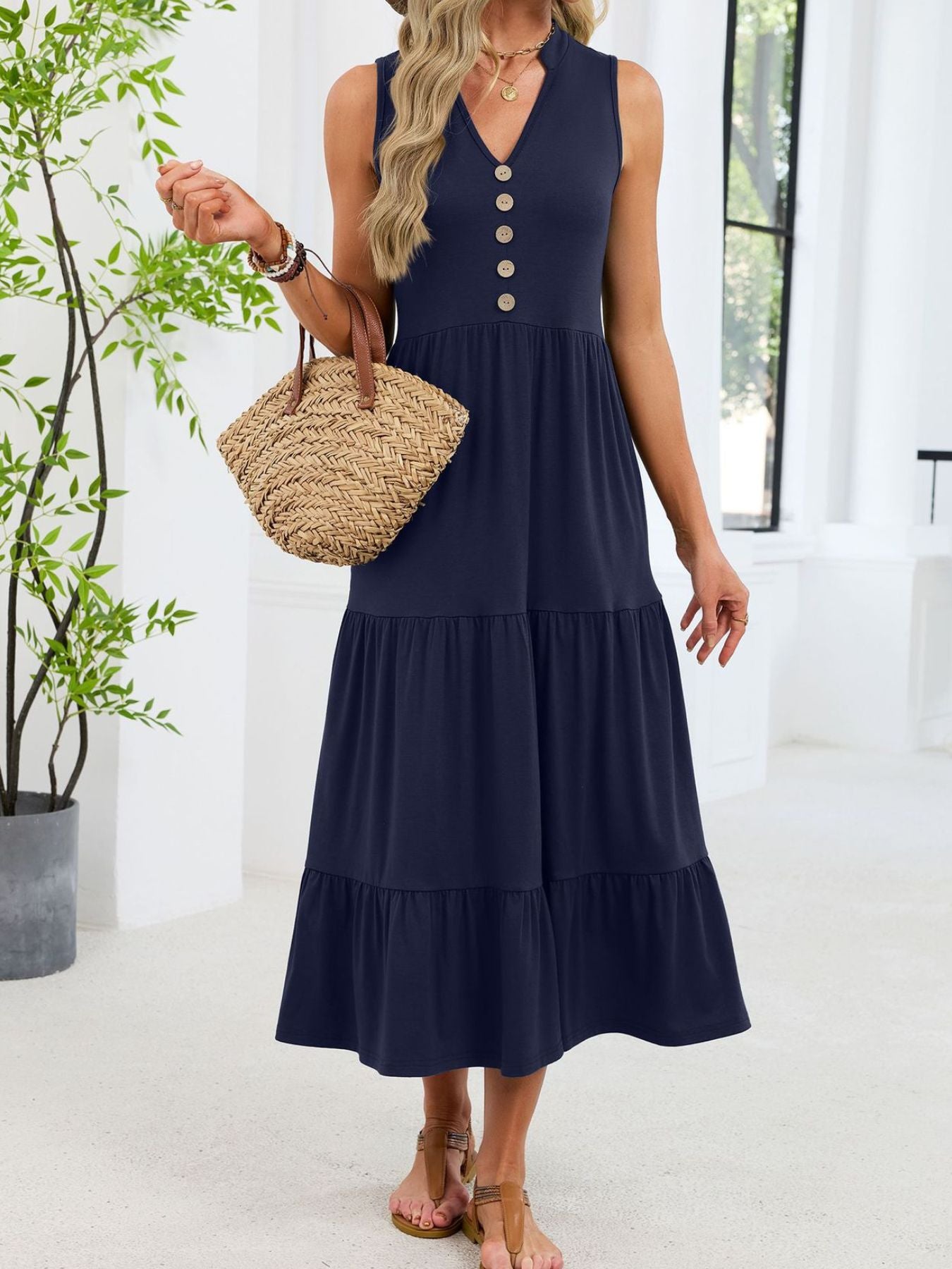 Navy tiered midi dress with notched V-neck and decorative buttons.