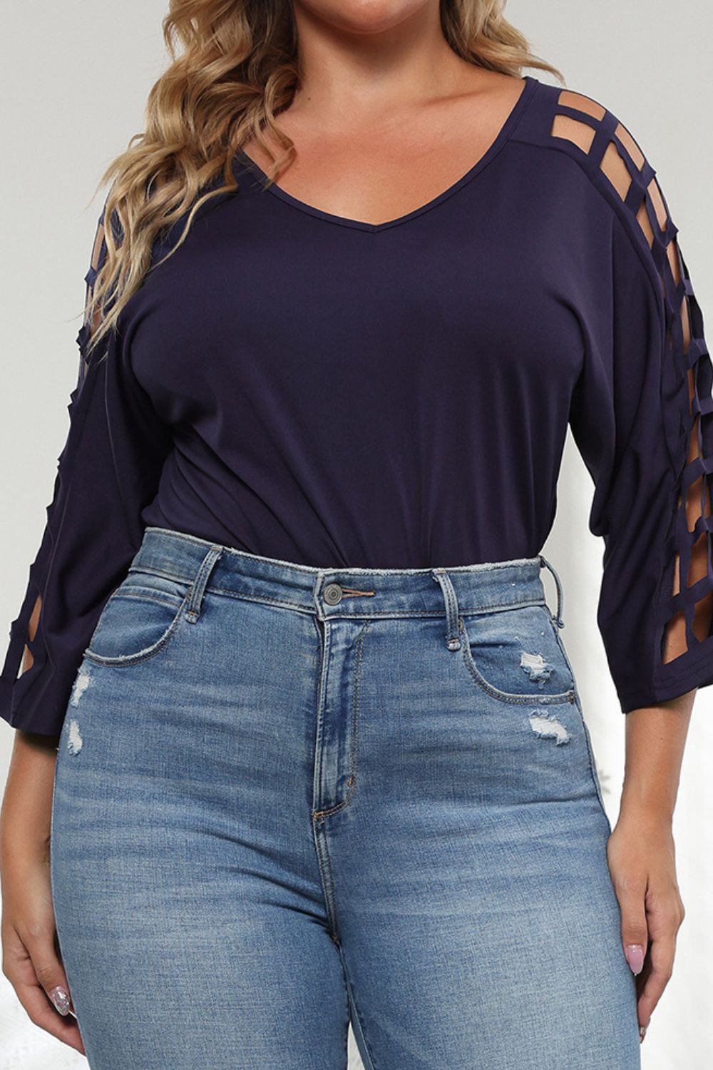 Dark navy v-neck blouse with lattice cutout sleeves and 3/4 length sleeves.