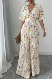 Floral pleated wide-leg jumpsuit with V-neck and short sleeves, cinched waist.