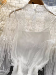 White lace blouse with cami, featuring sheer sleeves and ruffled hem.