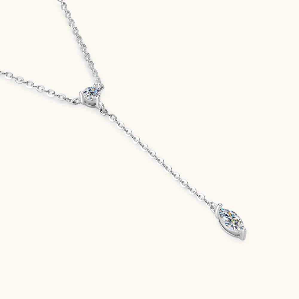 Silver lariat necklace with marquise moissanite pendant and round accent stone.
