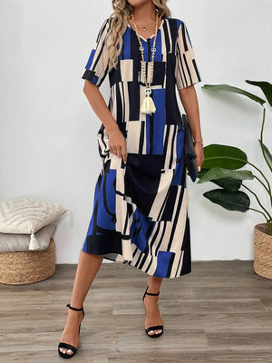 Geometric V-neck midi dress in blue, black, and cream with short sleeves and a relaxed fit.