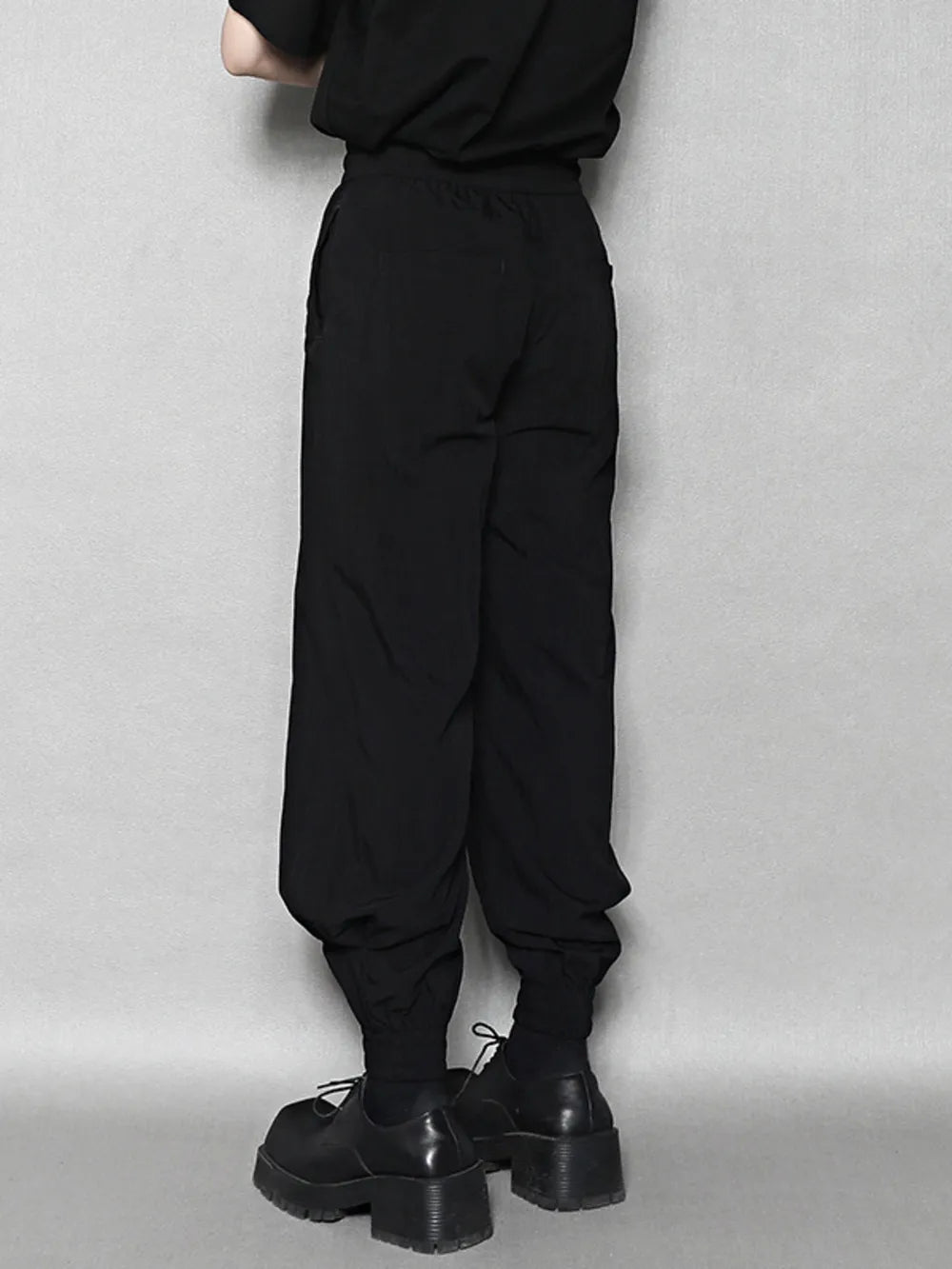 Black sweatpants with drawstring waist and elastic ankle cuffs.