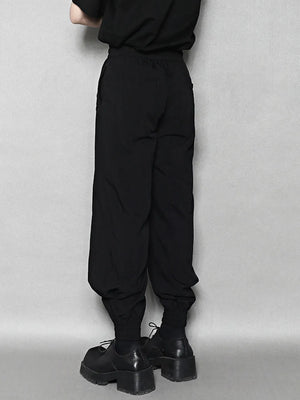 Black sweatpants with drawstring waist and elastic ankle cuffs.
