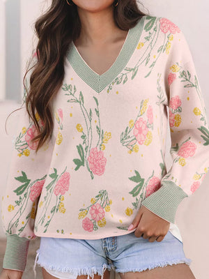 Floral v-neck knit sweater with relaxed fit, featuring pink and yellow flowers on a light pink background.