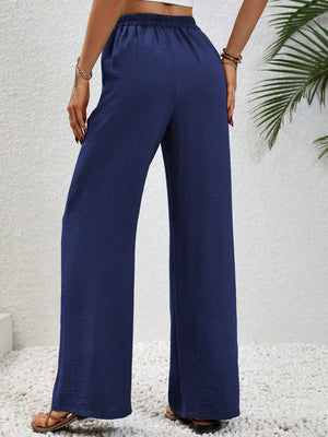 Dark blue textured palazzo trousers with drawstring waist and wide legs.