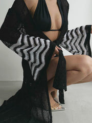 Black knit duster with chevron pattern on bell sleeves, open front, and crochet detail.