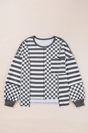 Asymmetrical knit top in black with patchwork stripes and checkerboard pattern.