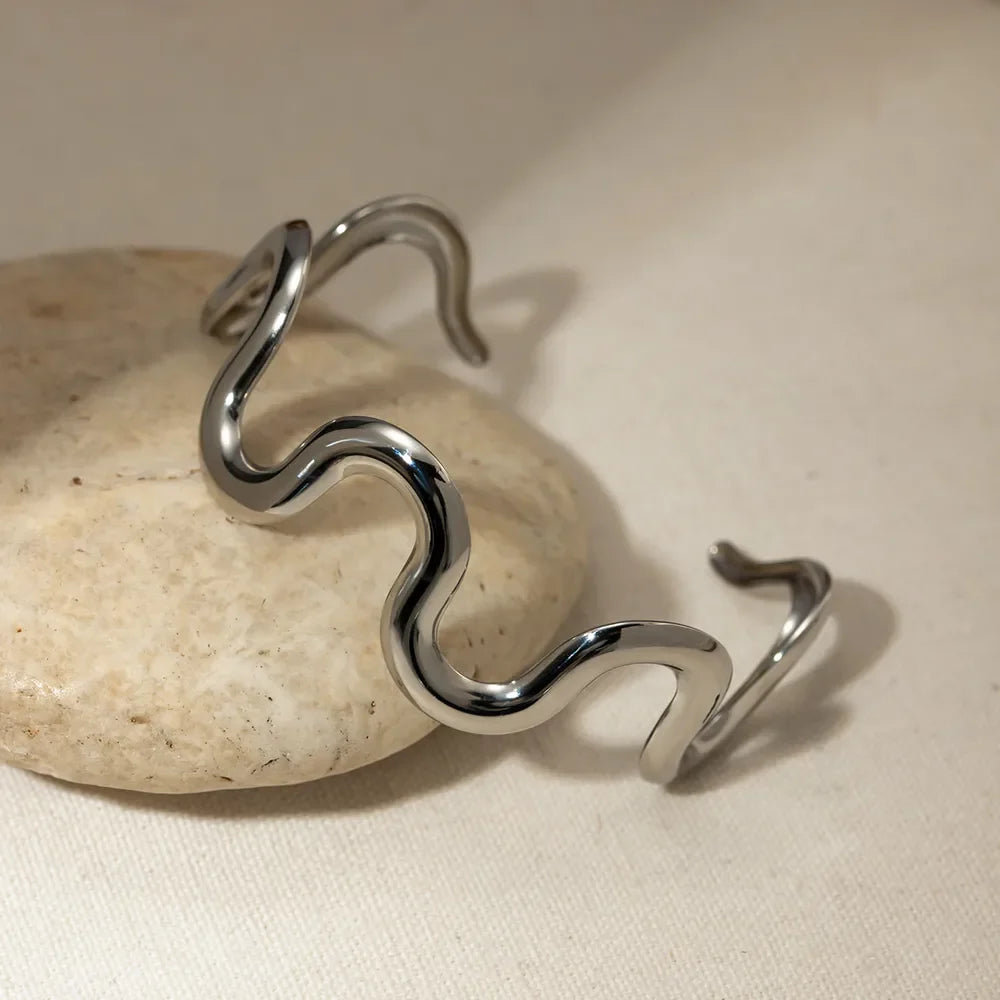 Sculptural ripple cuff bracelet in silver with a wavy, artistic design.
