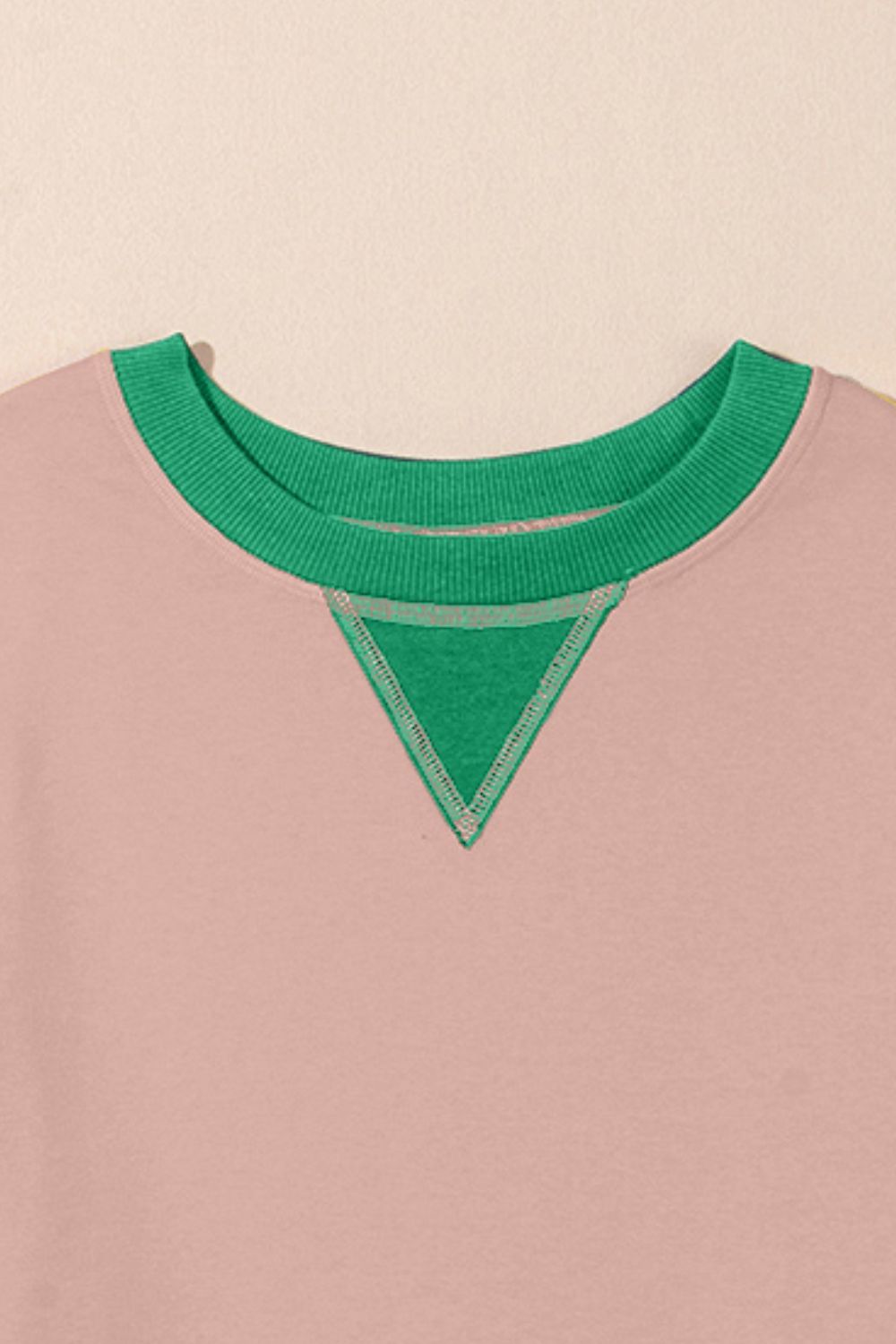 Pink crewneck sweatshirt with green contrast neckline and triangle detail