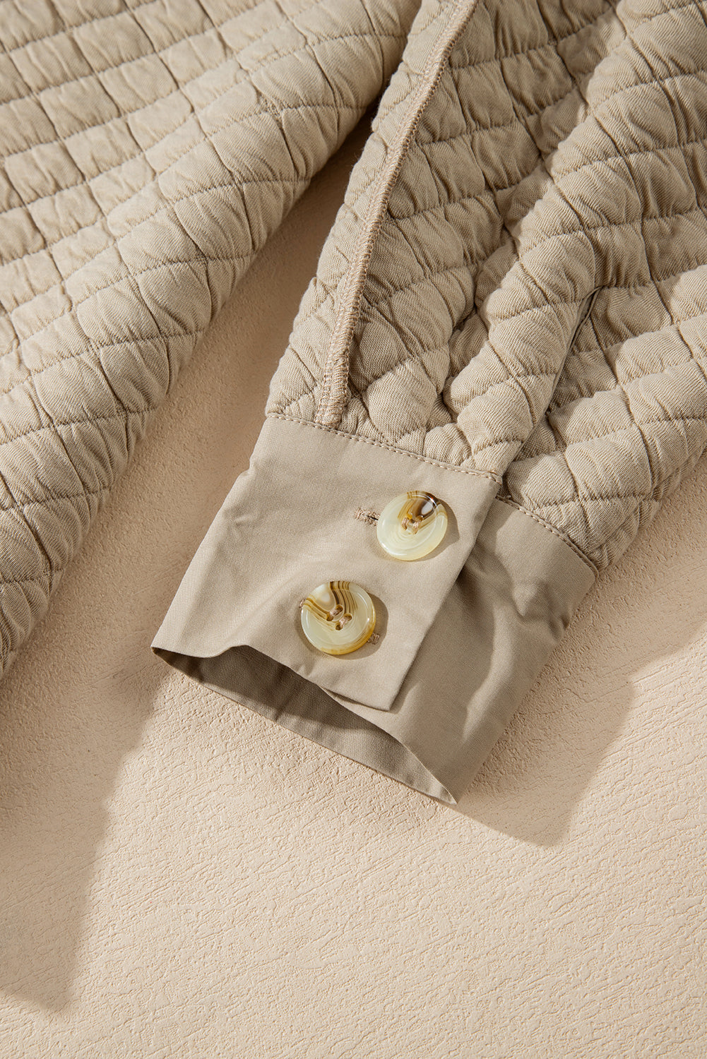 Beige diamond quilted oversized button-up jacket with tortoise shell buttons.