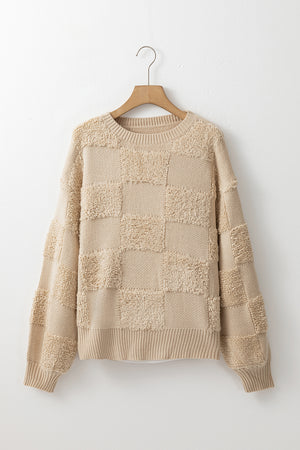 Beige textured checkerboard knit sweater with crewneck and ribbed cuffs and hem.