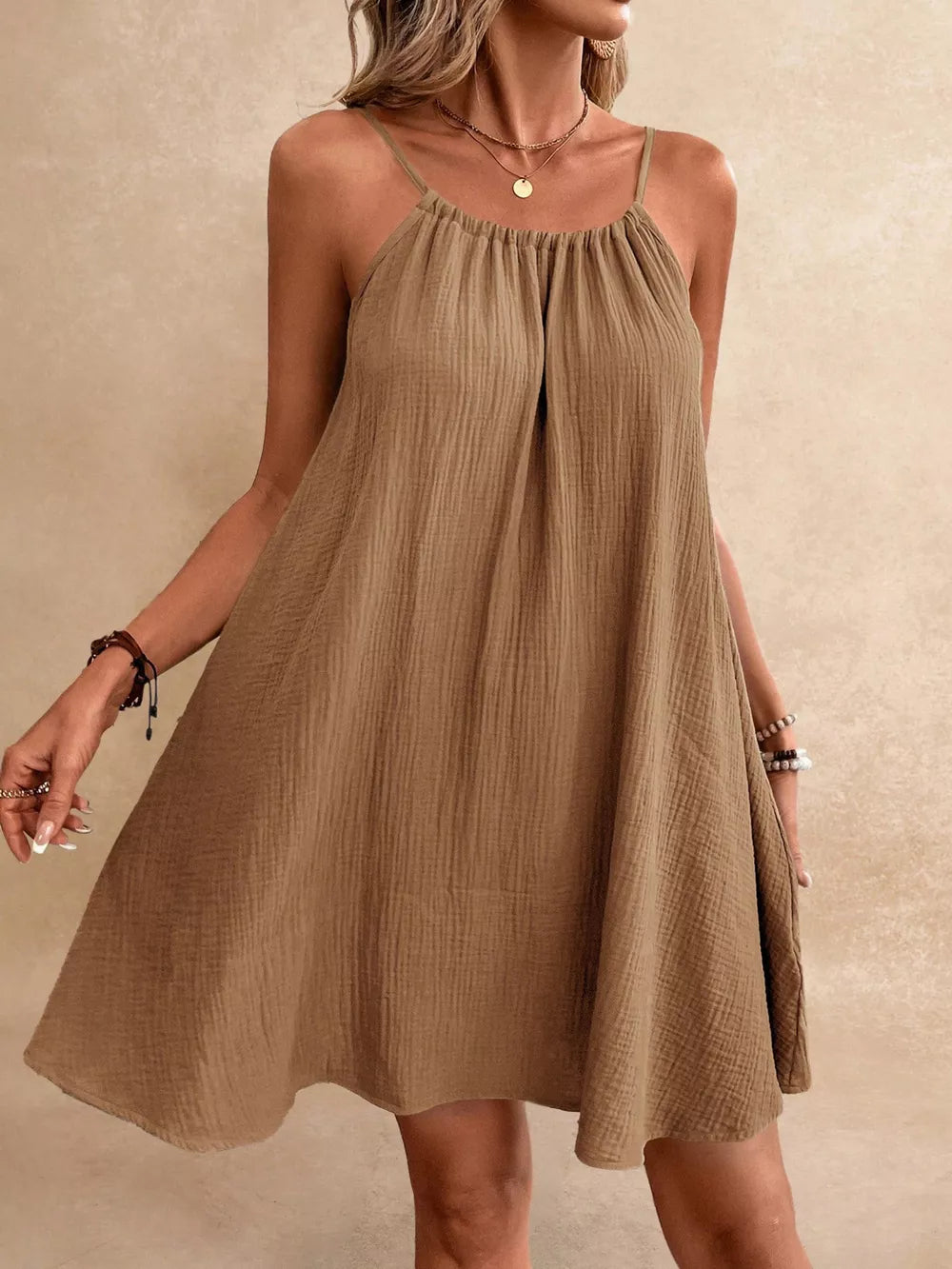 Light brown spaghetti strap gauze dress with textured fabric and gathered neckline.