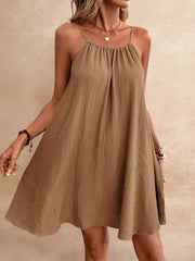 Light brown spaghetti strap gauze dress with textured fabric and gathered neckline.