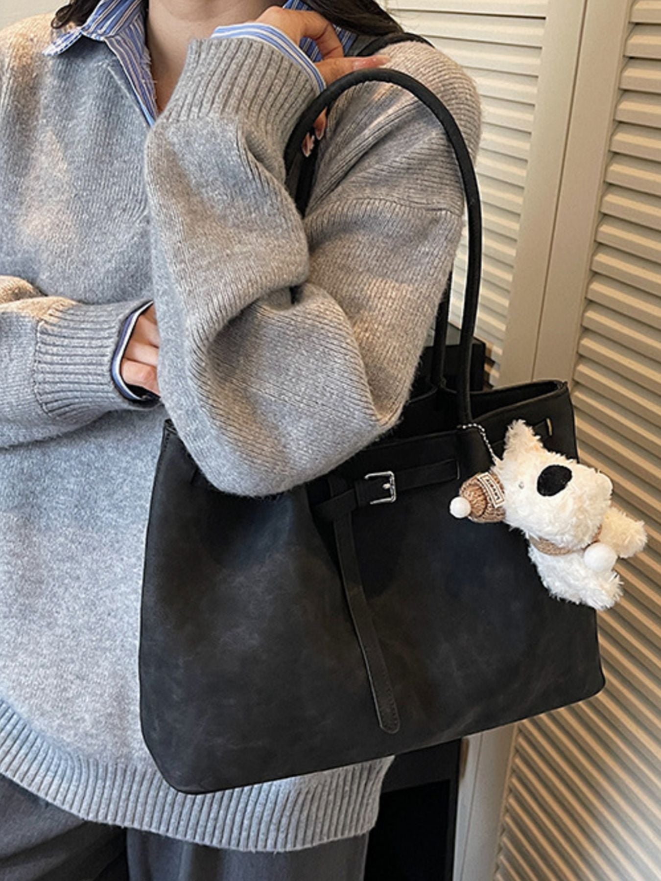 Black shoulder bag with buckle accent and dog charm
