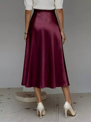 Wine red satin A-line midi skirt with pockets, flowing silhouette.