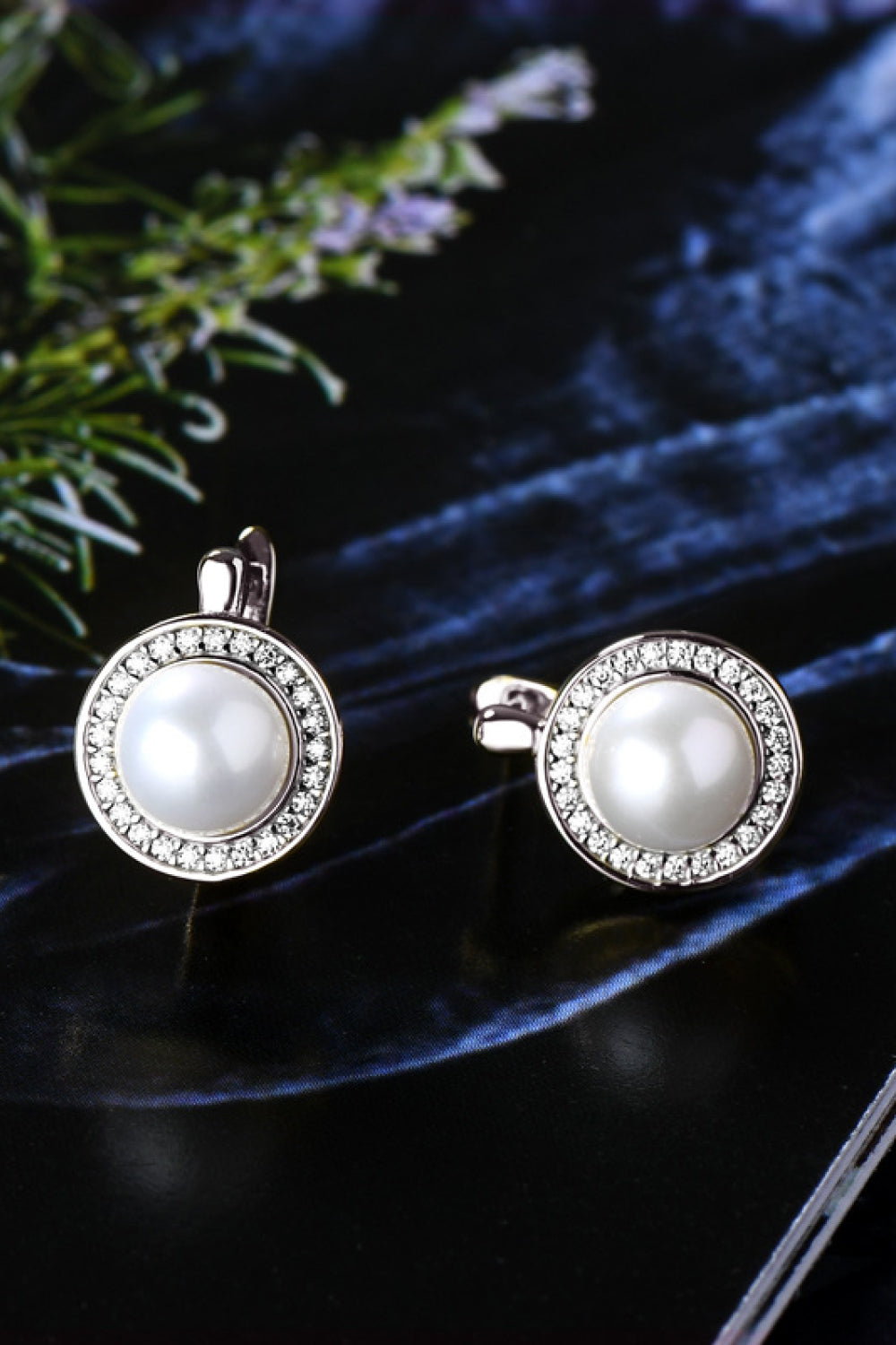 Pearl halo leverback earrings with crystal accents and a central pearl.