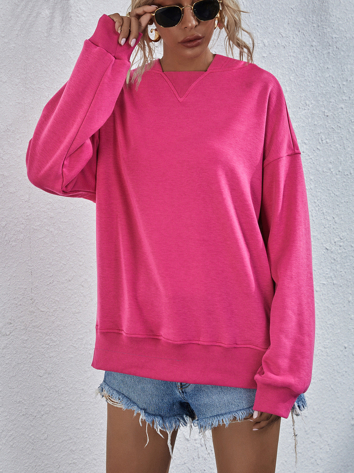 Boxy hot pink sweatshirt with V-neck detail and split hem