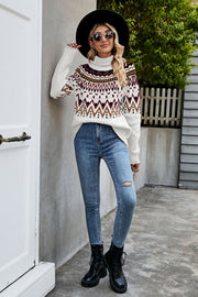 Geometric knit turtleneck sweater in white with brown, burgundy, and black pattern.