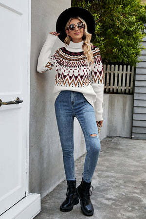 Geometric knit turtleneck sweater in white with brown, burgundy, and black pattern.