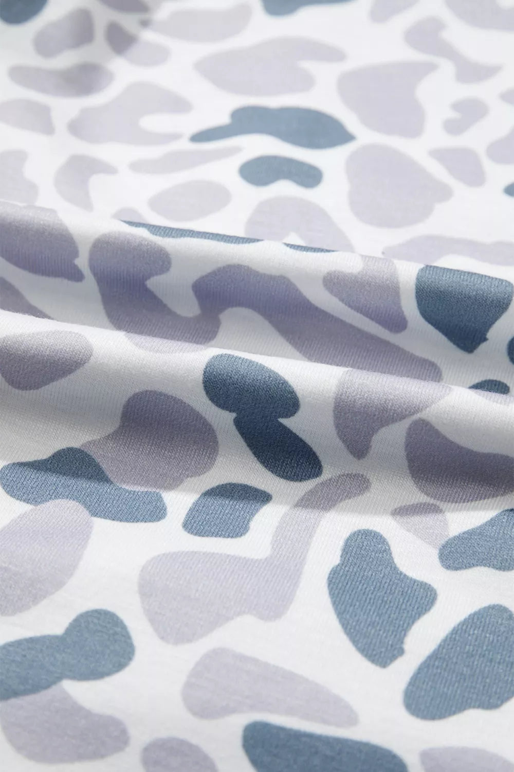 Camouflage print pajama fabric with blue and grey abstract shapes on white.