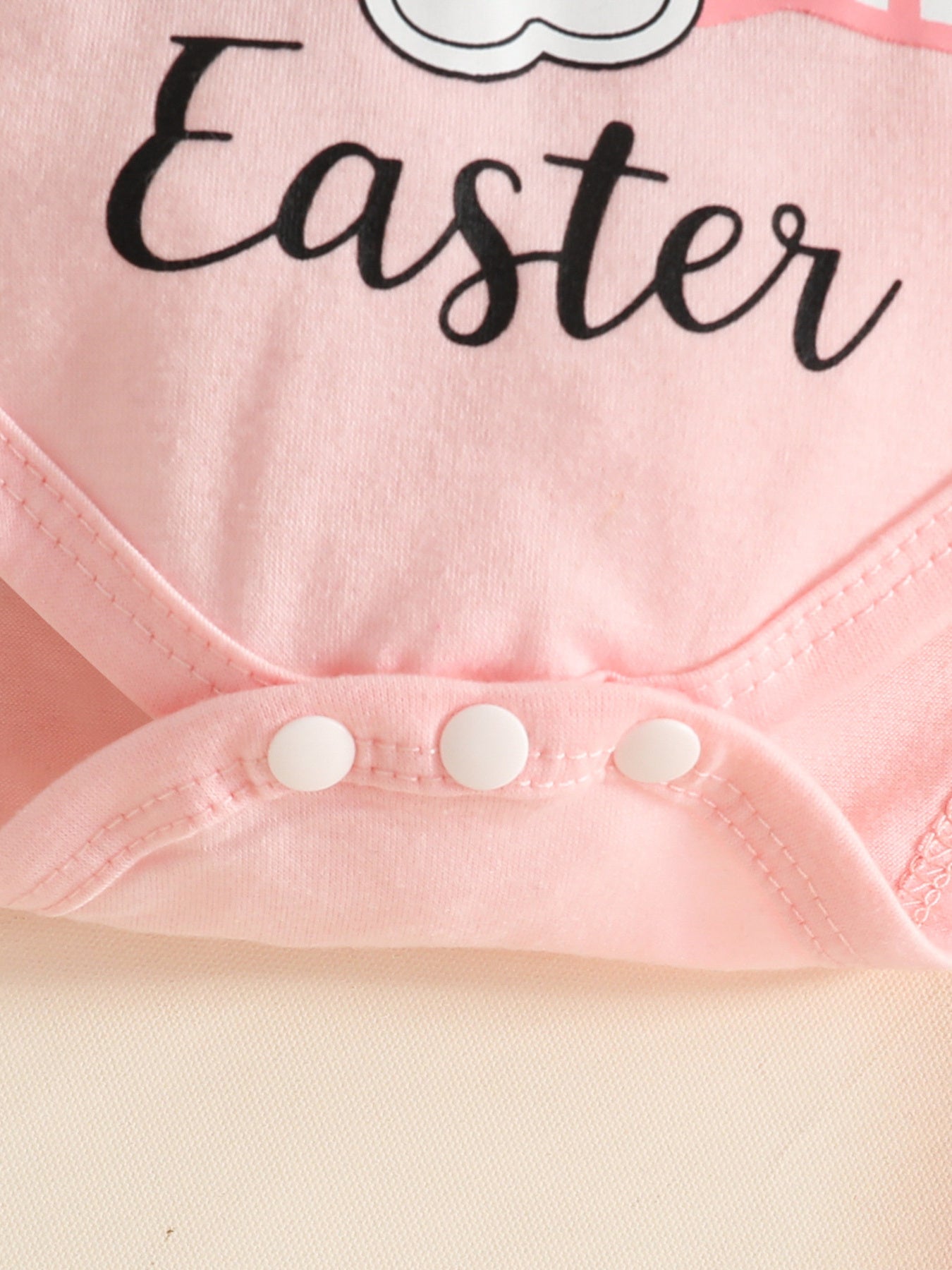 Pink baby bodysuit with Easter bunny graphic and snap closure