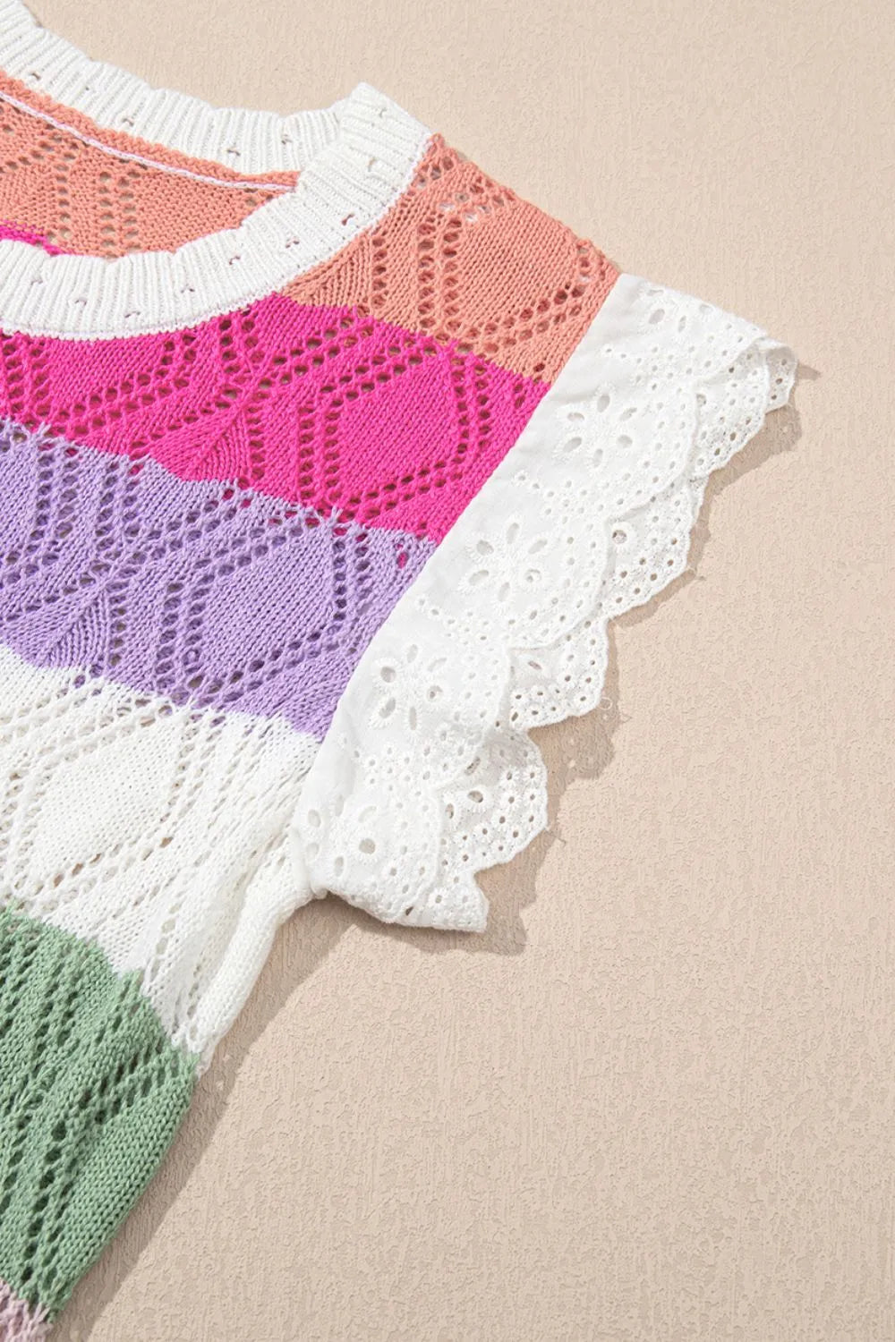 Rainbow crochet blouse with eyelet flutter sleeves and striped pattern.